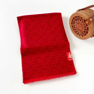 Festive red jacquard scarf with traditional lucky patterns and fringe. Perfect winter wear.