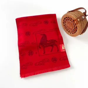 Close-up detail of the red Chinese New Year scarf featuring auspicious horse and cloud patterns.