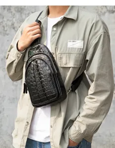 Close-up detail of genuine leather men chest bag with crocodile pattern and zippers.