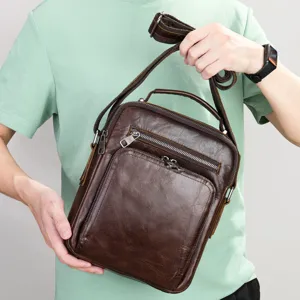 Detailed close-up view of brown leather shoulder bag showing the sturdy zipper and quality hardware.