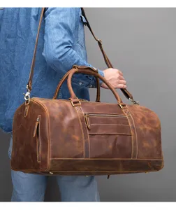 Detailopname van vintage reistas van echt leer voor heren met stevige handvatten.