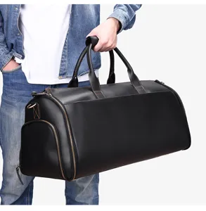 Black leather travel duffel bag detail showing large capacity and sturdy top handles.