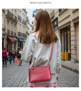 Detailed shot of a red leather crossbody bag worn by a model walking on a European street.