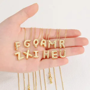 Gold 3D bubble letter pendant necklace detail closeup showing shiny metal finish and delicate chain.