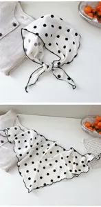 Foulard triangulaire en coton à pois noir et blanc, accessoire élégant pour le cou ou la tête.