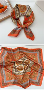 Close-up detail of the orange silk square scarf featuring elegant baroque and Greek key patterns.