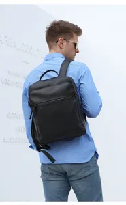 Vue arrière détail du sac à dos en cuir noir sur le modèle, montrant la texture.