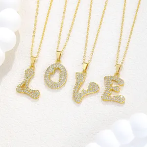 Nahaufnahme Detail von funkelnden Zirkonia Buchstaben und Herz Anhänger Halsketten.