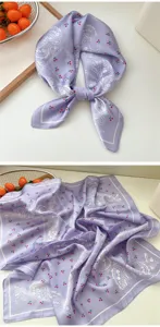 Detailed close-up view of purple satin square scarf with cute cherry and paisley print.