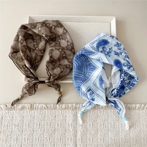 Close-up detail of stylish cotton-linen paisley print lazy square scarves in brown and blue.