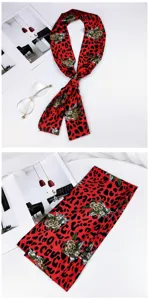 Detailed view of red leopard floral skinny silk scarf, stylish neckerchief accessory.