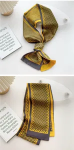 Detailed view of women's stylish yellow and grey polka dot narrow scarf, elegant neck ribbon.