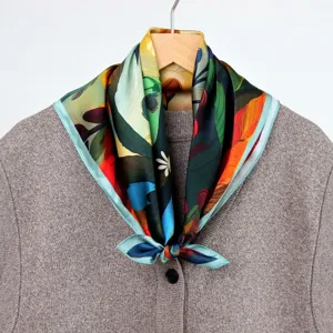 Close-up detail of the oil painting style silk scarf draped on a chic knit cardigan.