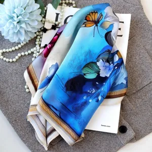 Close-up detail of luxury oil painting style silk scarf with vibrant floral and butterfly prints.