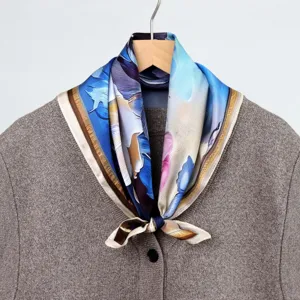 Silk square scarf detail showing artistic oil painting blue floral design and elegant fabric.