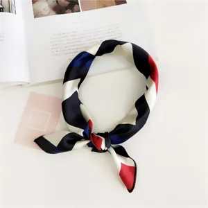Detailed close-up shot of a chic geometric color-block silk scarf in an elegant flat lay style.