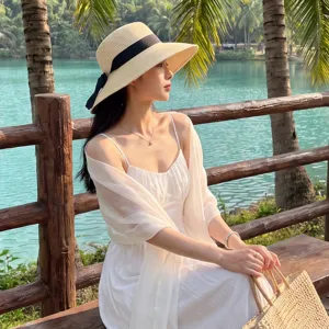 Outdoor lifestyle detail shot showcasing a lightweight white silk shawl worn gracefully by a lake.
