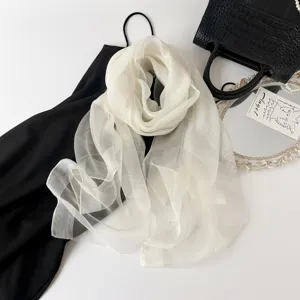 Detailed view of a white sheer silk scarf draped elegantly, perfect for lightweight styling.