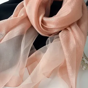 Silk scarf detail shot, lightweight translucent peach pink gauze shawl for women elegant look.