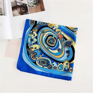 Close-up detail view of a blue artistic square silk scarf featuring a unique geometric spiral pattern.
