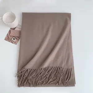 Detail view of a cozy taupe cashmere-feel tassel scarf, soft winter accessory on clean white.