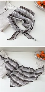Détail de foulard triangulaire rayé en coton montrant la texture et le style élégant.