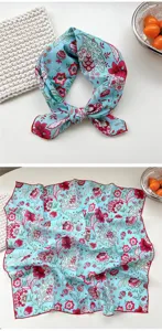 Floral print cotton square scarf detail, blue bandana with red flowers and rolled hem.