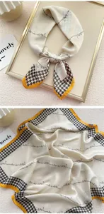 Dettagli in primo piano del foulard in seta con classico motivo pied-de-poule e bordo giallo.