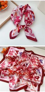 Red floral square silk scarf detail view, elegant neckwear close-up, smooth fabric texture.