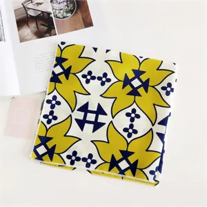 Close-up of a stylish geometric floral square silk scarf, ideal as a chic neckerchief accessory.