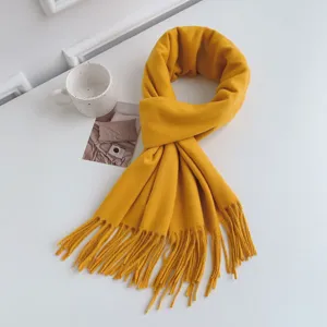 Detail view of a cozy yellow imitation cashmere tassel scarf, soft winter accessory texture.