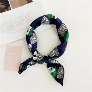 Detailed view of women's small silk square scarf, navy blue with chic green white geometric print.