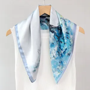 Close-up detail of the blue and white abstract oil painting silk square scarf on display.