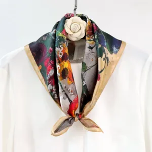 Silk square scarf detail showing oil painting floral print and elegant white camellia brooch.