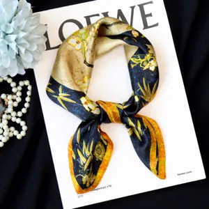 Close-up detail of oil painting floral silk scarf with elegant knot on white art magazine.