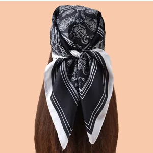 Gros plan détail du foulard carré en satin avec imprimé cachemire noir et blanc élégant.