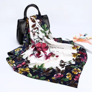 Detailed view of luxury satin floral silk scarf with elegant typography design in a studio setting.
