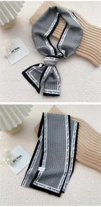 Detail d'un foulard fin pied-de-poule noir et blanc avec joli bord imprime et tissu doux.