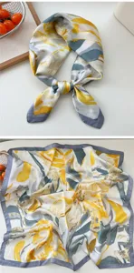 Detailed view of the elegant silk square scarf featuring vibrant yellow and grey abstract prints.