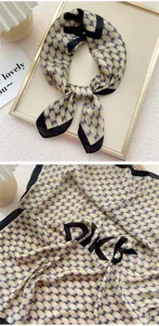 Primo piano dettagliato del foulard in seta con motivo pied-de-poule e lettere chic.
