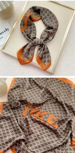 Piccolo foulard di seta elegante per donna, design con monogramma marrone e bordo arancione.