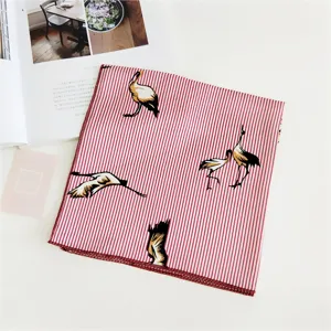 Detail view of a red striped square scarf with elegant crane pattern for women fashion.