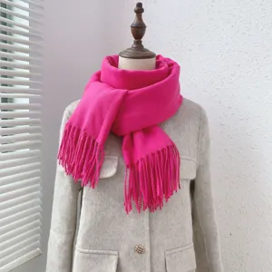 Close-up detail of the bright pink imitation cashmere scarf featuring delicate fringe trim.