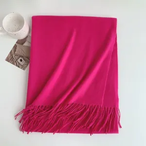 Detailed view of a bright magenta faux cashmere winter scarf with elegant fringe design.
