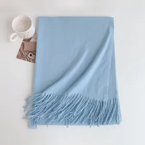 Close-up of light blue imitation cashmere tassel scarf, showing fine texture and soft fringe.