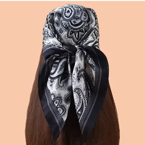 Vue de détail d'un carré de soie à imprimé cachemire noir et blanc, accessoire élégant.
