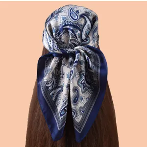 Vue détail de foulard carré femme 70cm présentant un élégant motif cachemire bleu satiné.