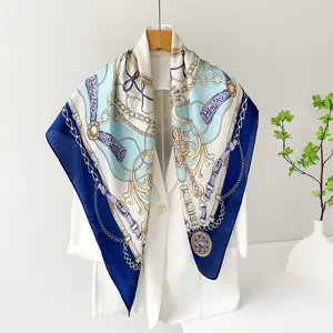 Detail view of a luxury blue and white satin silk square scarf with chain pattern.