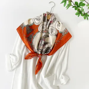 Detail view of the elegant satin silk square scarf featuring a retro carriage and tassel print.