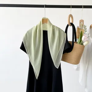 Elegante lichtgroene zijdeachtige dunne vierkante sjaal voor dames aan een hanger